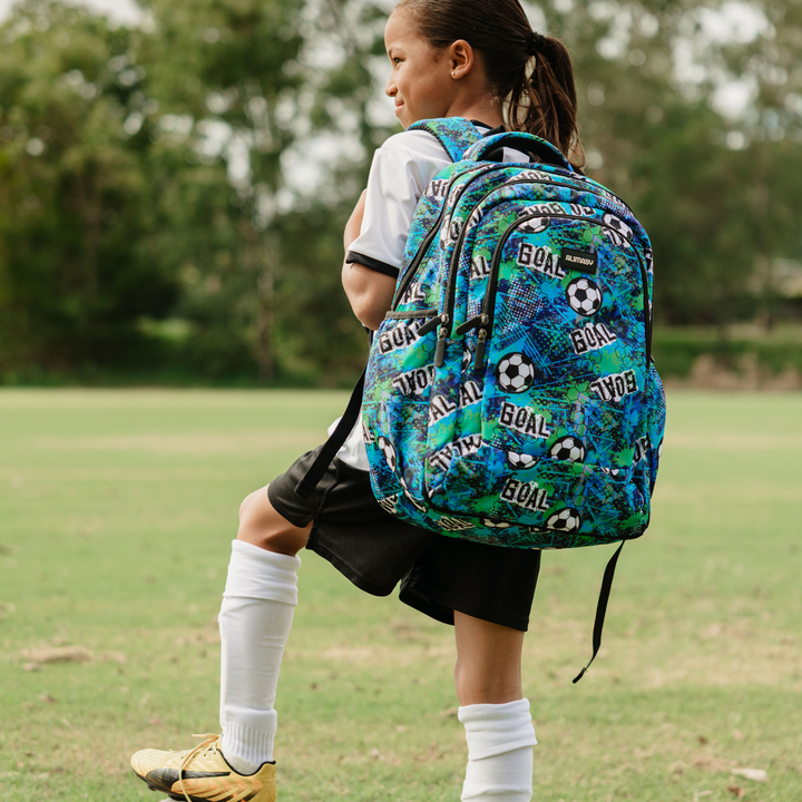 Child with a colorful soccer backpack on a grassy field