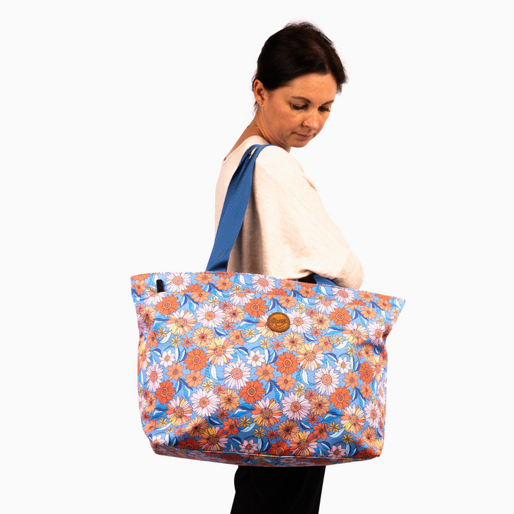 woman model wearing alimasy shoulder tote bag with orange flowers and blue background