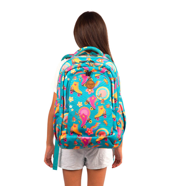 girl wearing green alimasy backpack with pink and yellow roller skates pattern